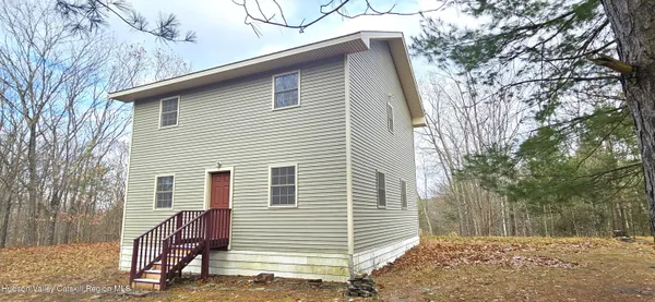 a view of a house with a backyard and trees