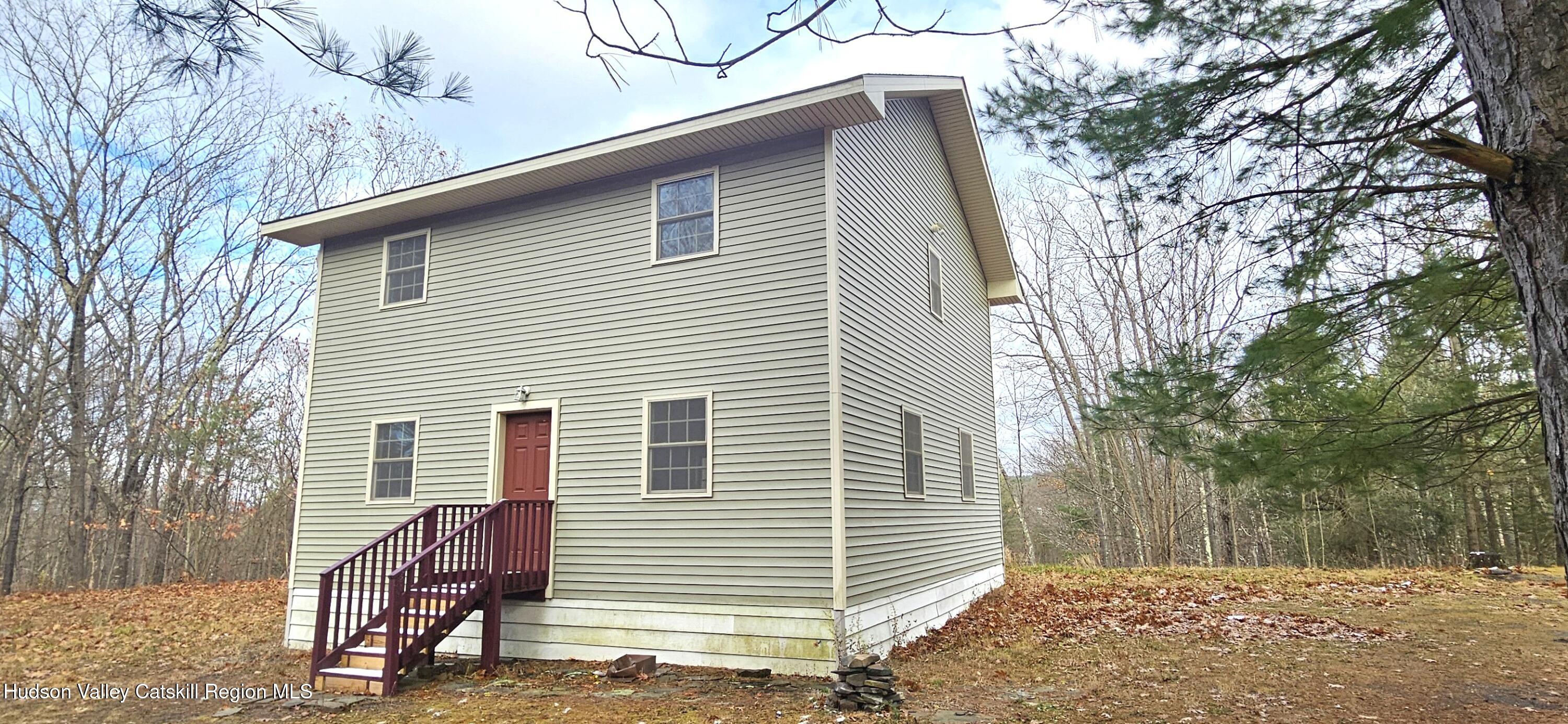 a view of a house with a backyard and trees
