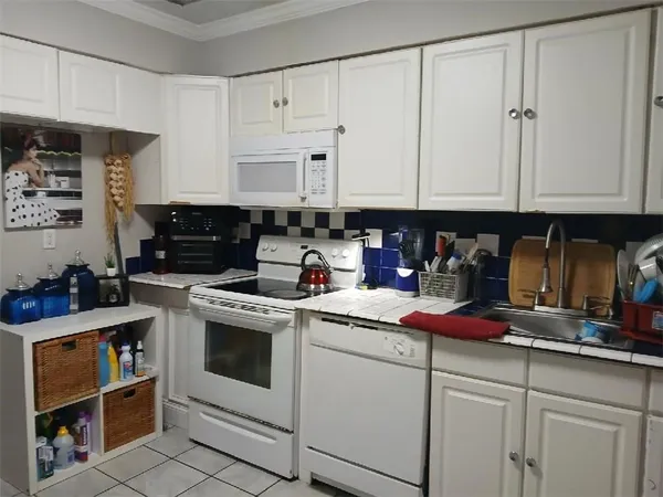 a kitchen with white cabinets and white appliances