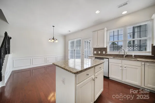 a kitchen with granite countertop white cabinets and white appliances