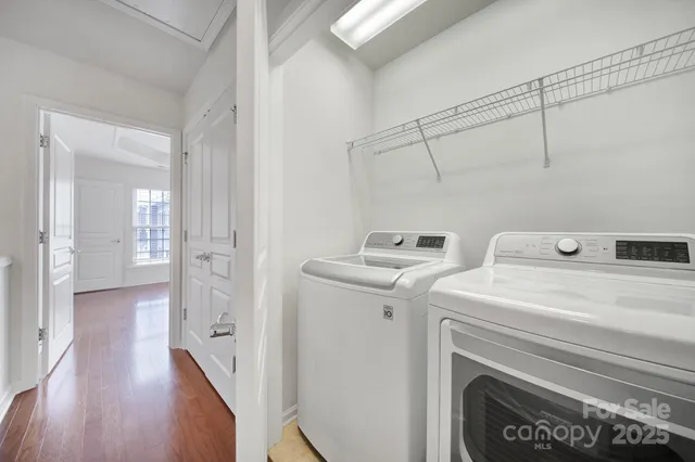 a view of washer and dryer with bathroom in the background