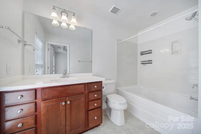 a bathroom with a bathtub shower sink vanity and toilet