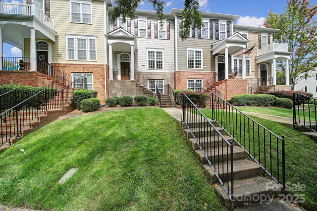 a view of a brick house with a yard and plants
