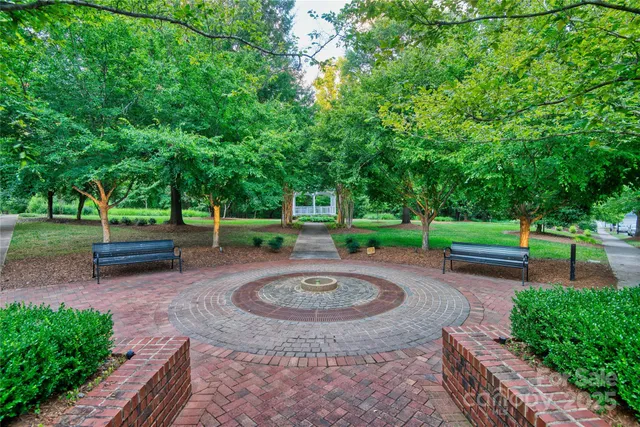a view of a back yard with flower plants and wooden fence