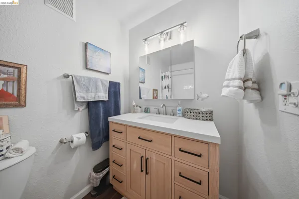 a bathroom with a sink vanity granite and toilet