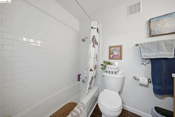 a white toilet sitting next to a bath tub