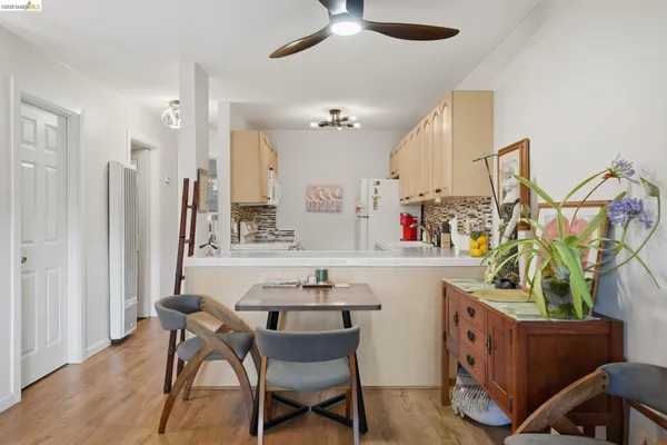 a kitchen with stainless steel appliances a table chairs refrigerator and sink