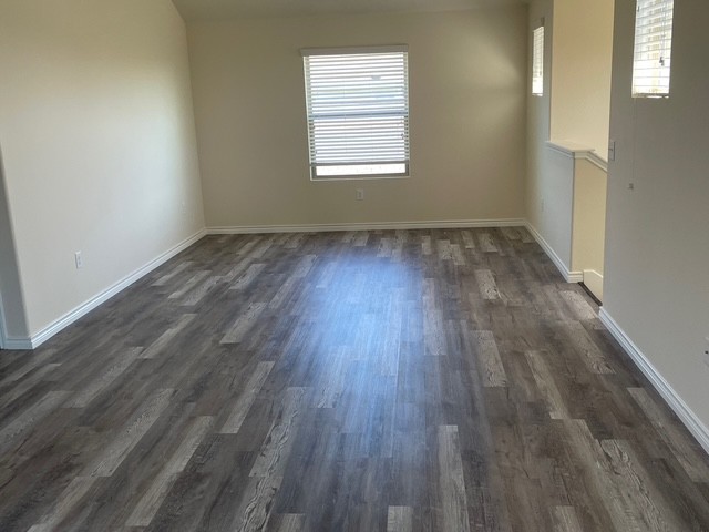 10125 Gertrudis Loop Austin, TX 78747 - Photo 14 of 27 Empty room with baseboards and dark wood-style flooring