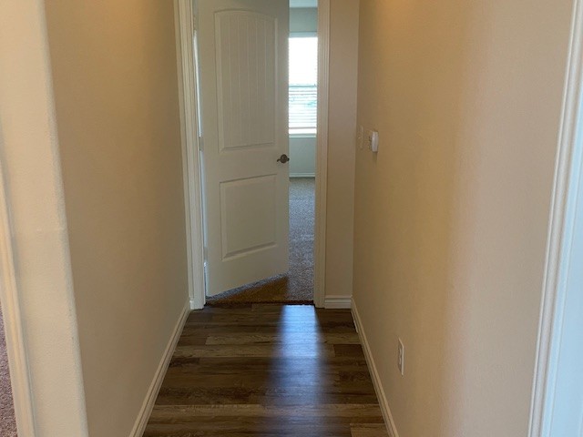 10125 Gertrudis Loop Austin, TX 78747 - Photo 20 of 27 Corridor featuring baseboards and dark wood finished floors