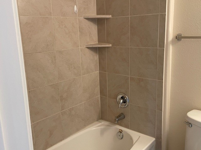 10125 Gertrudis Loop Austin, TX 78747 - Photo 22 of 27 Bathroom featuring a textured wall and washtub / shower combination