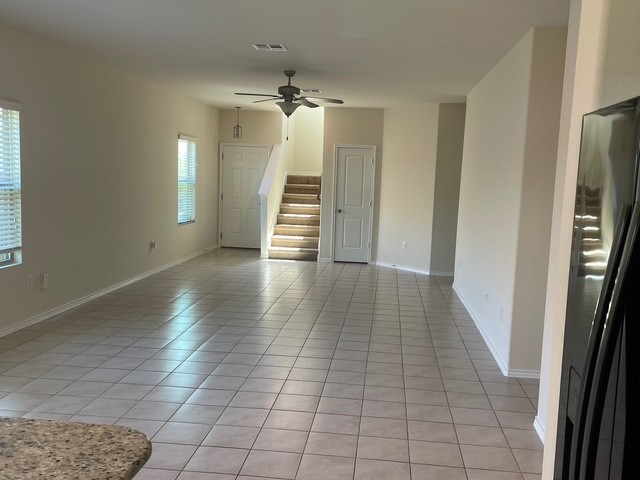 10125 Gertrudis Loop Austin, TX 78747 - Photo 2 of 27 Unfurnished living room featuring ceiling fan and light tile patterned floors