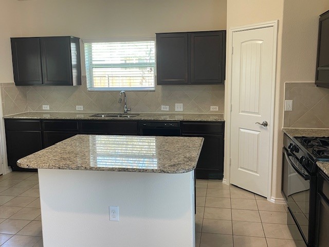 10125 Gertrudis Loop Austin, TX 78747 - Photo 5 of 27 Kitchen featuring black appliances, light stone counters, tasteful backsplash, light tile patterned floors, and a kitchen island