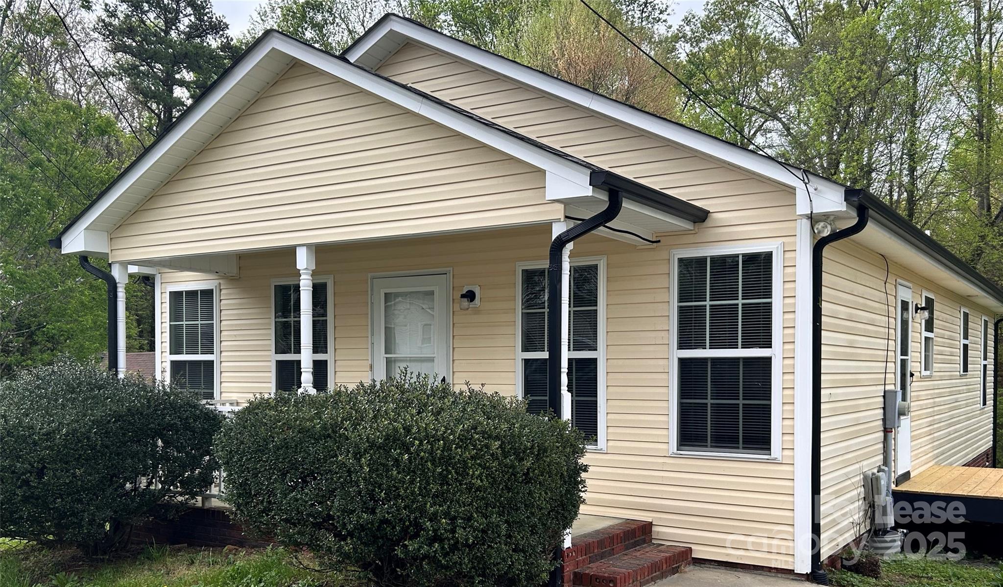 a view of a white house next to a yard