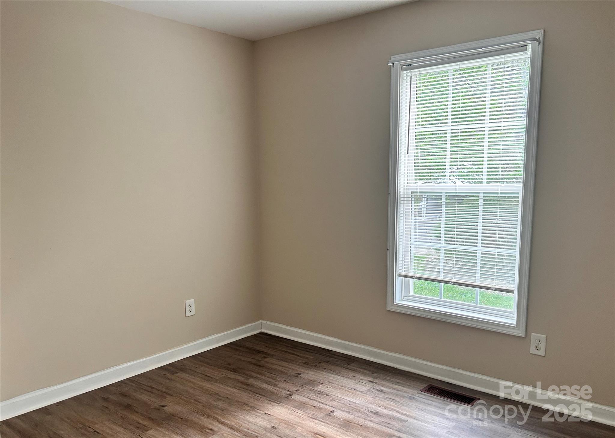 910 Aggie Street Kannapolis, NC 28083 - Photo 8 of 10 a view of an empty room with wooden floor and a window