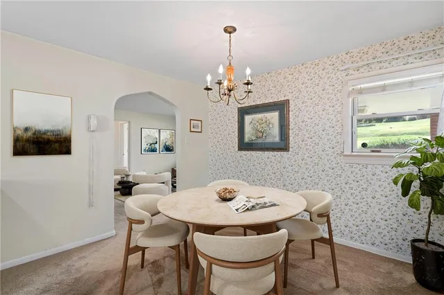 a view of a dining room with furniture and a chandelier