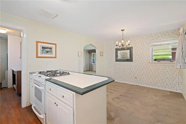 a kitchen that has a cabinets a stove and wooden floor