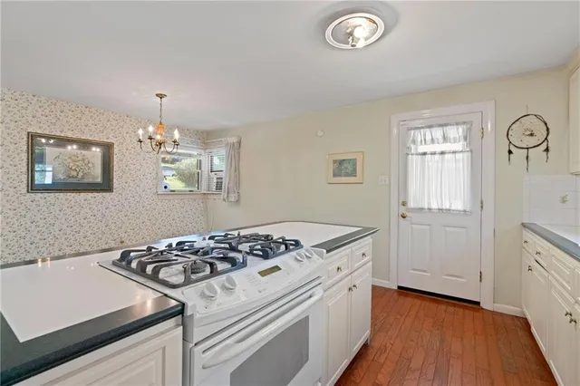 a kitchen that has a stove and a wooden floor
