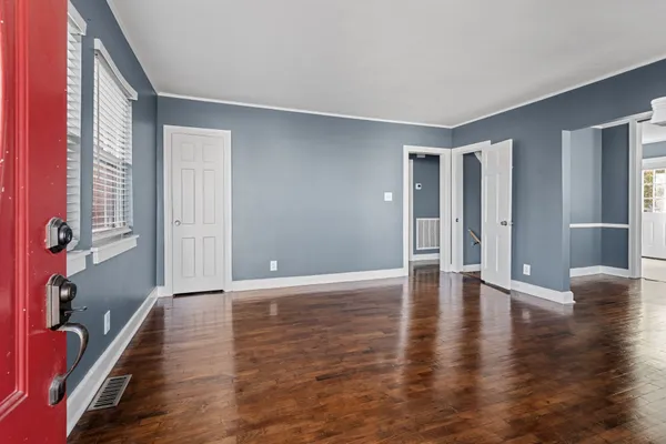 a view of empty room with wooden floor and fireplace