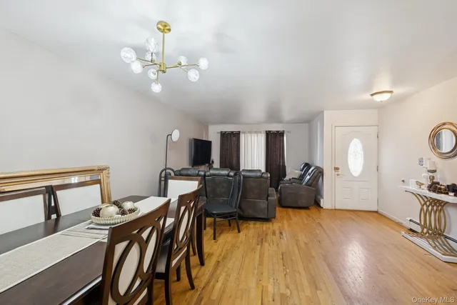 a living room with furniture a chandelier and wooden floor