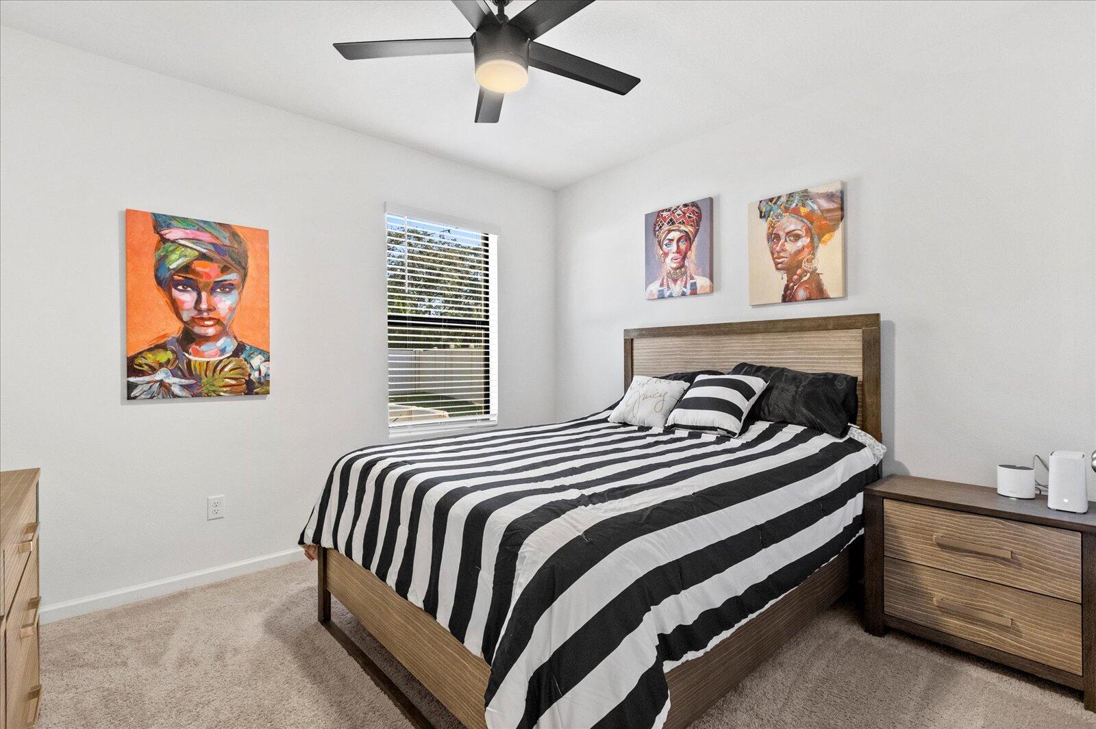 1671 Saxton Road Cocoa, FL 32926 - Photo 14 of 39 a bedroom with bed and paintings on the wall