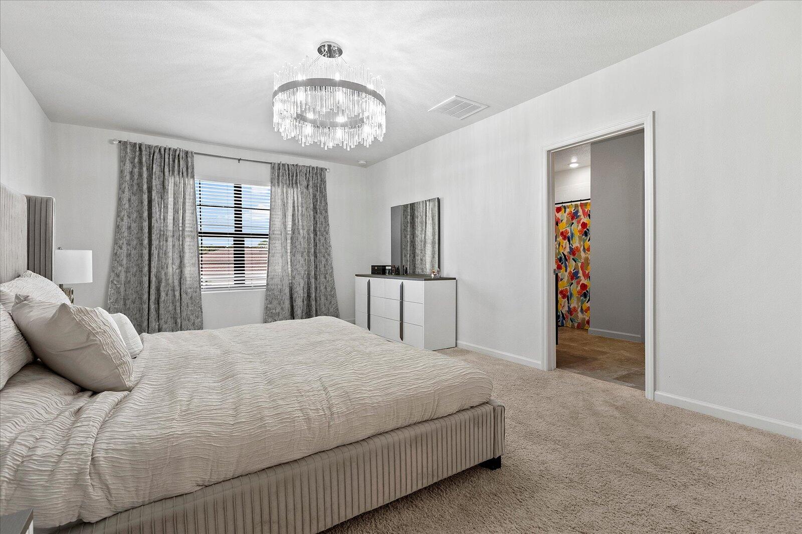 1671 Saxton Road Cocoa, FL 32926 - Photo 21 of 39 a bedroom with a large bed and a chandelier