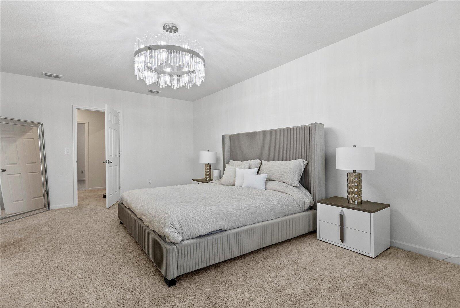 1671 Saxton Road Cocoa, FL 32926 - Photo 22 of 39 a spacious bedroom with a bed and a chandelier