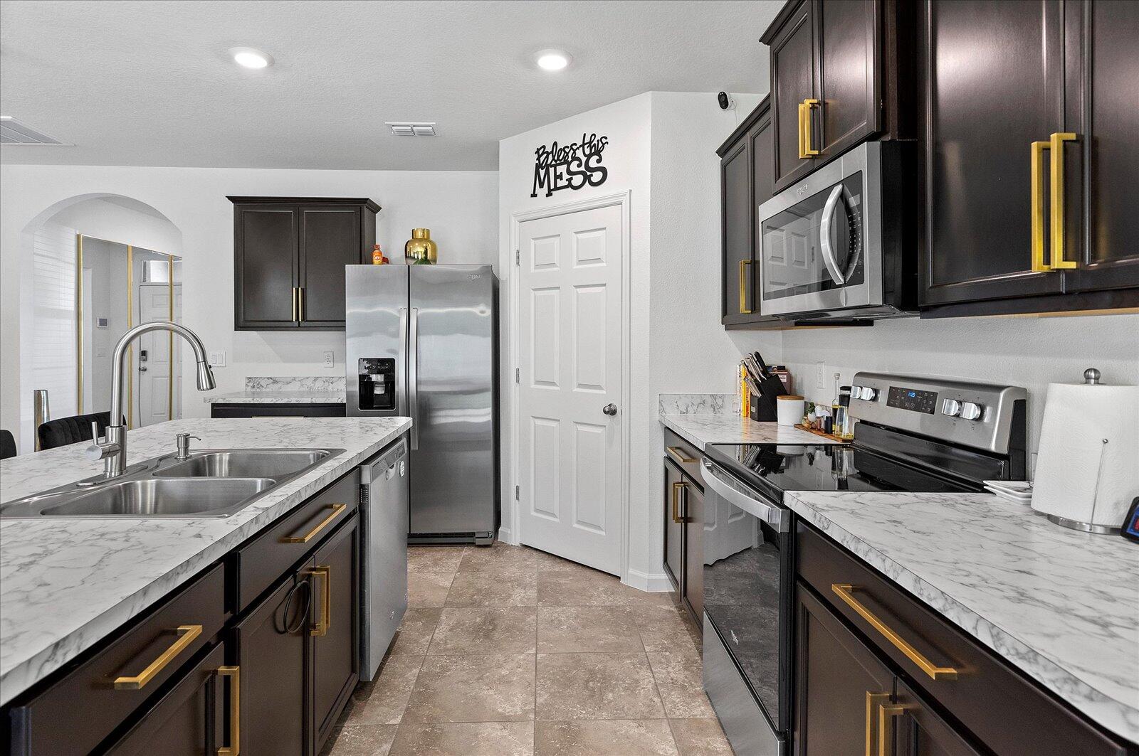 1671 Saxton Road Cocoa, FL 32926 - Photo 9 of 39 a kitchen with stainless steel appliances granite countertop a sink stove and refrigerator
