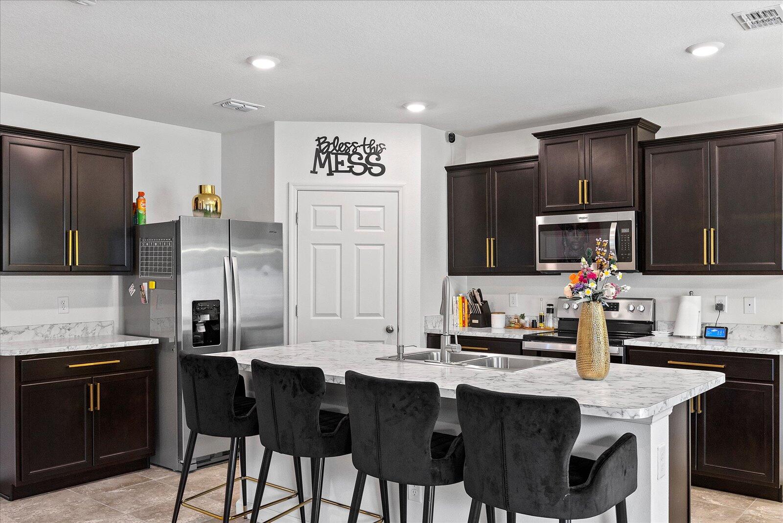 1671 Saxton Road Cocoa, FL 32926 - Photo 10 of 39 a kitchen with stainless steel appliances granite countertop a sink and a refrigerator