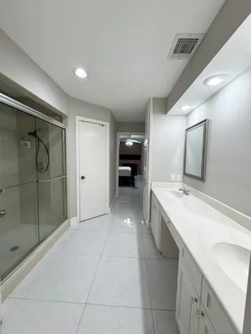 a bathroom with a double vanity sink mirror and shower