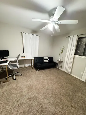 a living room with furniture and a ceiling fan