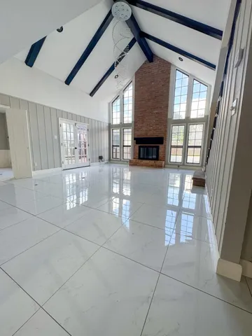 a view of an empty room with a fireplace and a window
