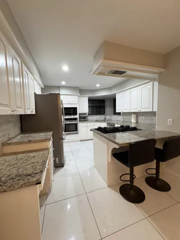 a kitchen with granite countertop a sink and a stove