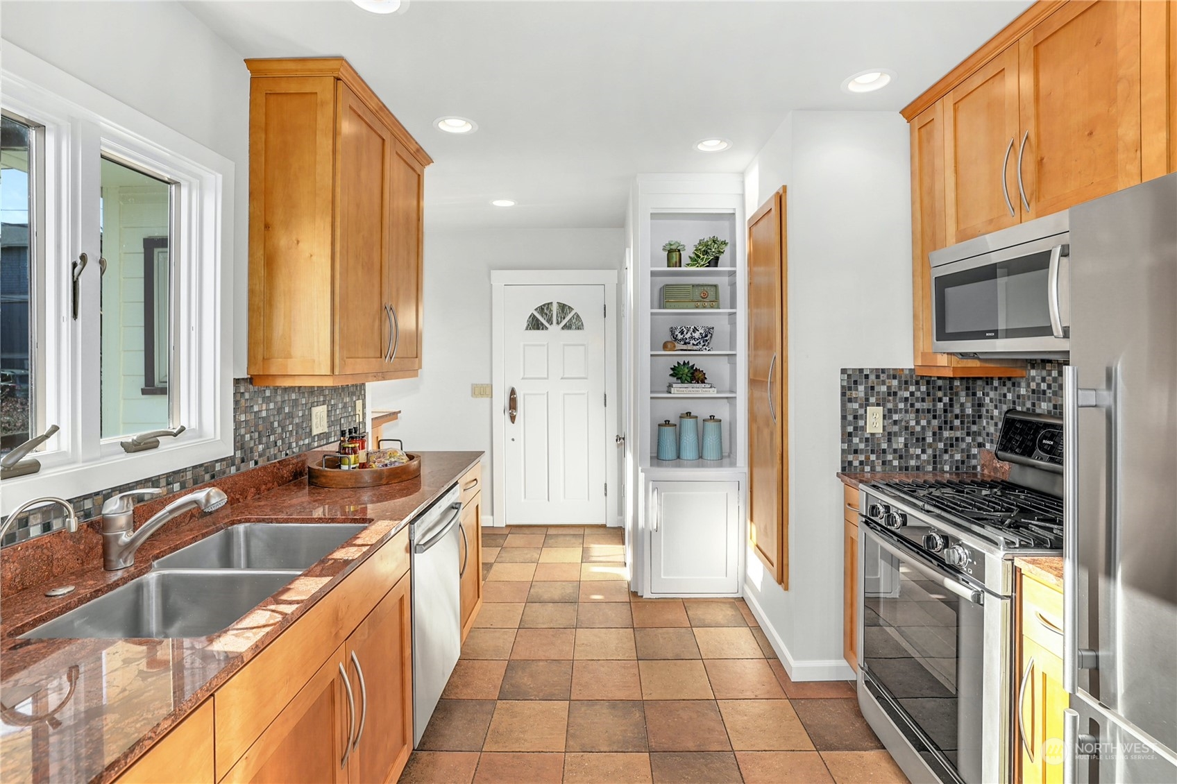3603 Bagley Avenue North Seattle, WA 98103 - Photo 12 of 38 a kitchen with stainless steel appliances granite countertop a sink and a stove top oven with wooden floor