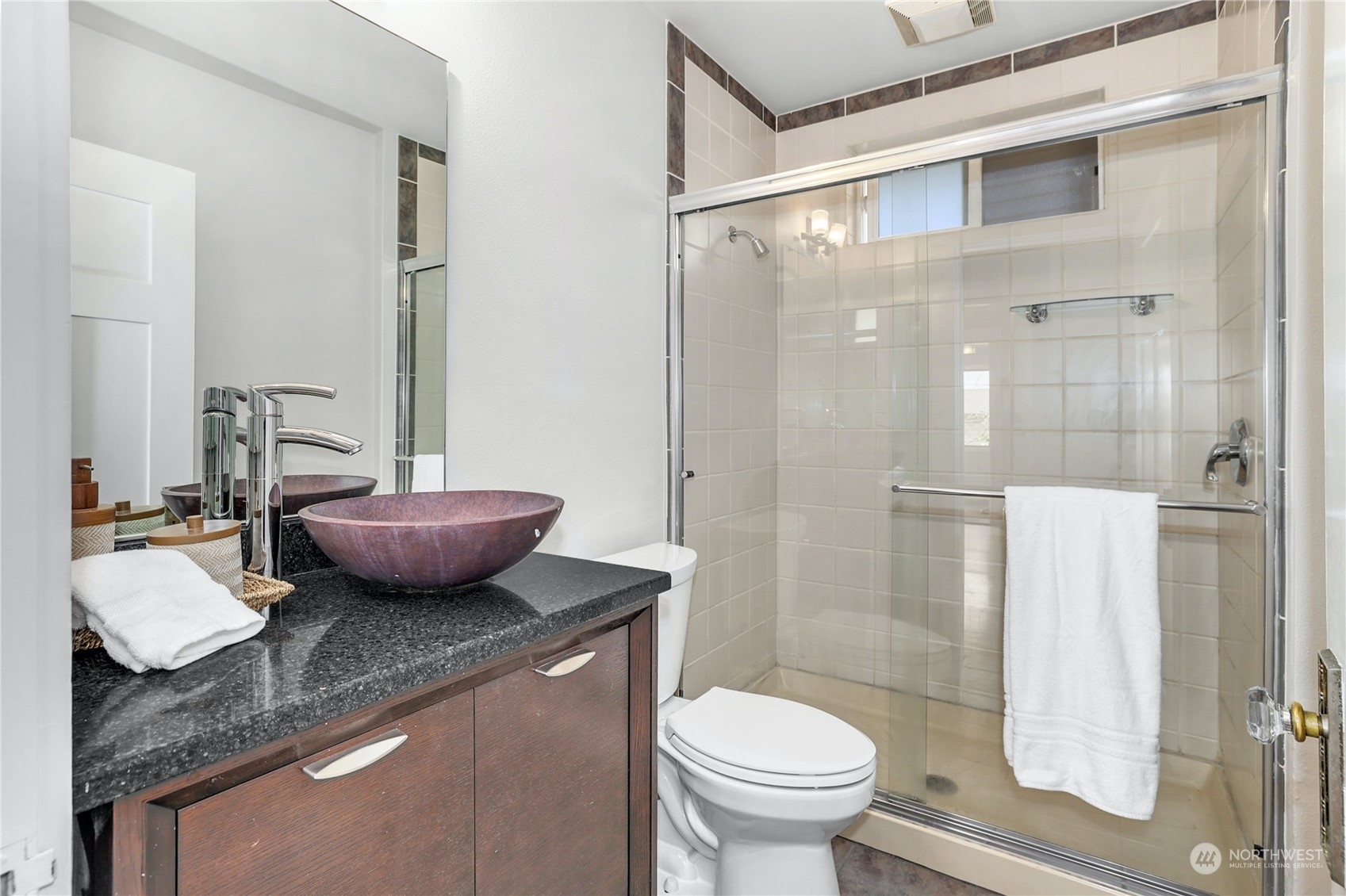 3603 Bagley Avenue North Seattle, WA 98103 - Photo 16 of 38 a bathroom with a granite countertop sink a toilet a mirror and shower