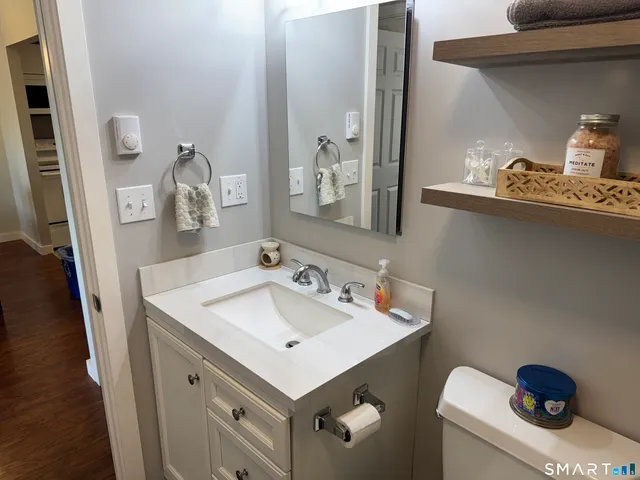 a bathroom with a sink toilet and mirror