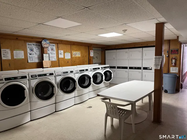 a utility room with dryer washer and stair