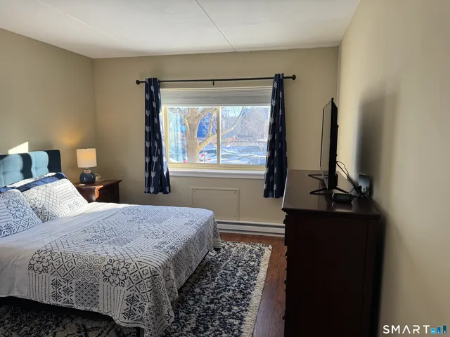a bedroom with a bed and a flat tv screen on a dresser