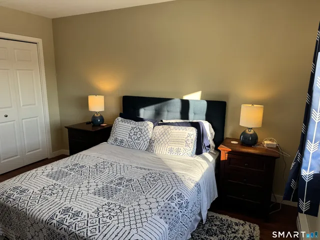 a bedroom with a bed and a lamp on dresser