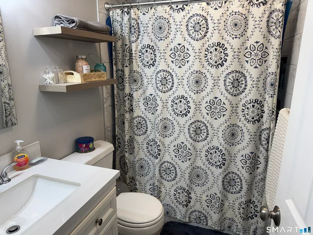 a bathroom with a toilet and shower curtain