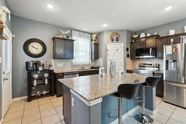 a kitchen with stainless steel appliances granite countertop a refrigerator oven stove microwave and cabinets