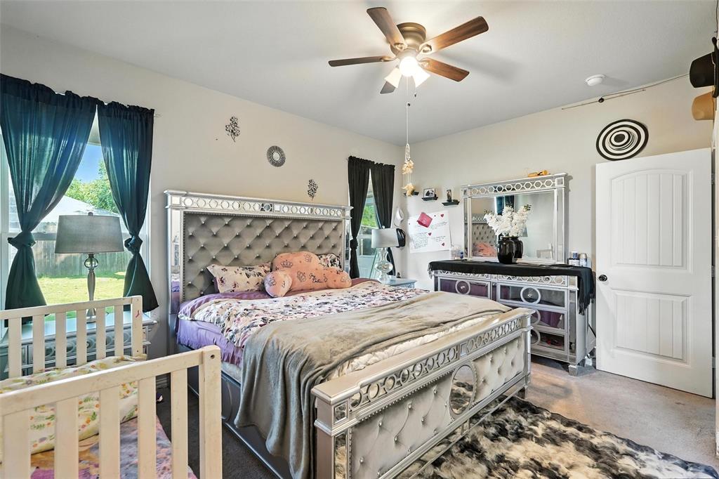 314 Frank Street Terrell, TX 75160 - Photo 21 of 40 a bedroom with a bed and a chandelier