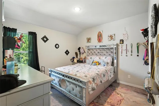 a bedroom with a bed and a refrigerator