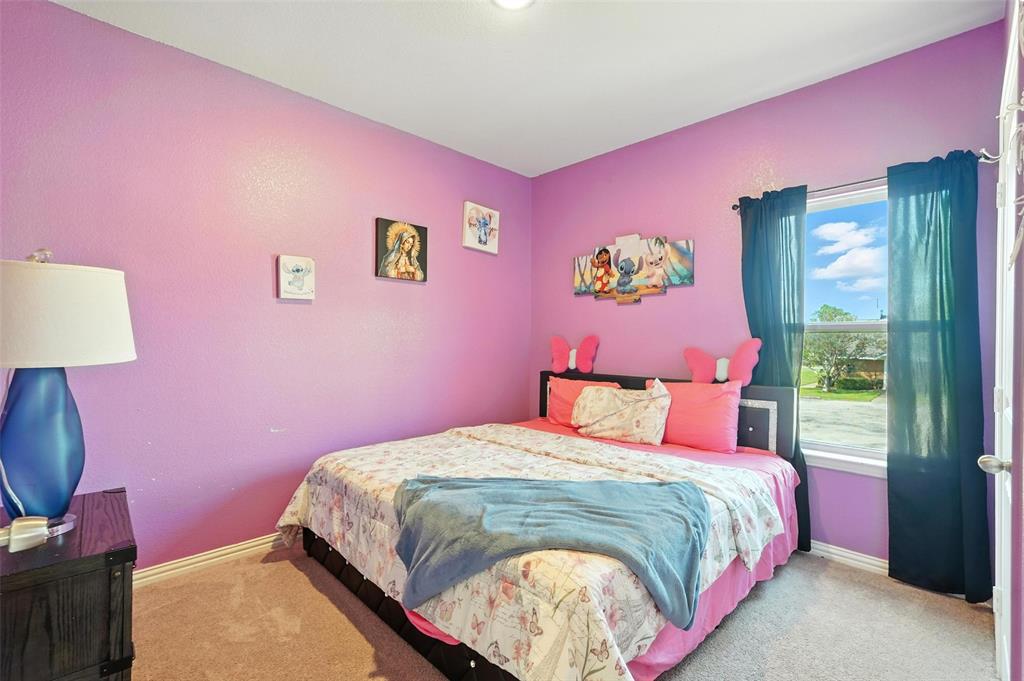 314 Frank Street Terrell, TX 75160 - Photo 29 of 40 a bedroom with pink walls and a bed
