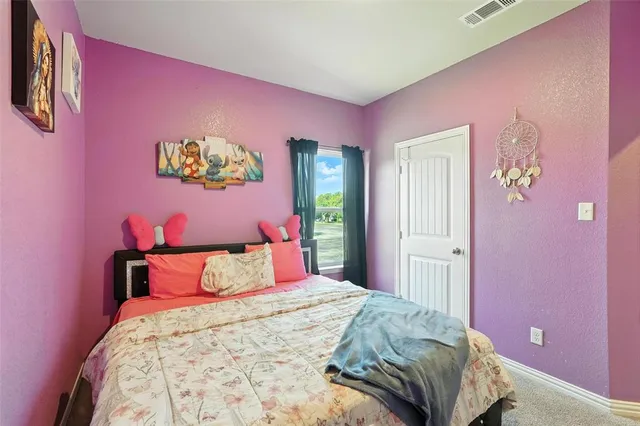 a bedroom with pink walls and a bed
