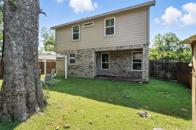 a patio with table and chairs and potted plants