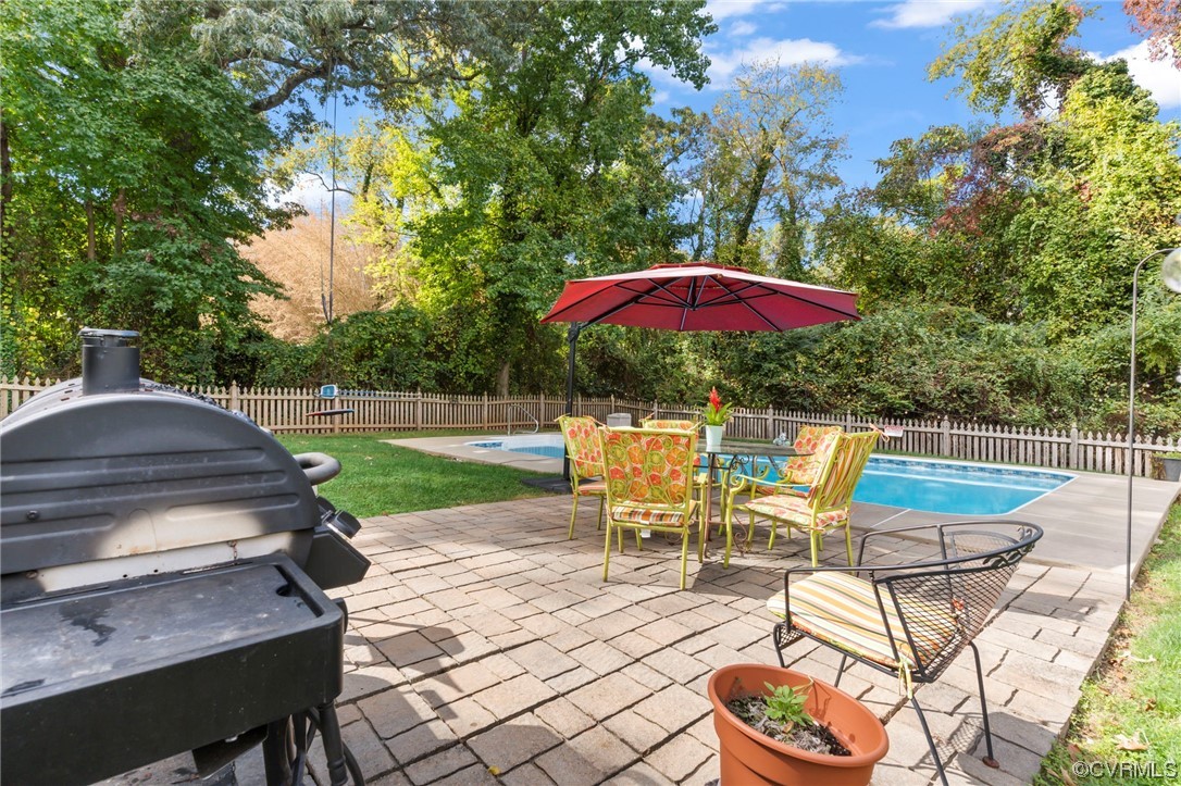 3800 Benton Avenue Richmond, VA 23222 - Photo 25 of 26 a view of a patio with table and chairs under an umbrella with a barbeque