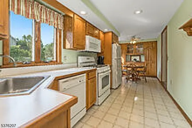 a kitchen with stainless steel appliances granite countertop a sink and a refrigerator