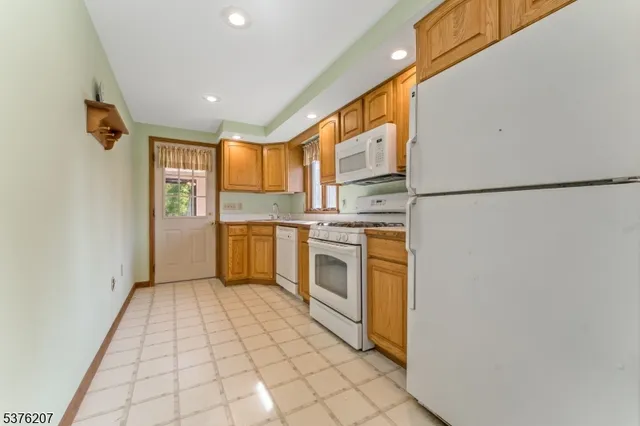 a kitchen with a refrigerator a stove top oven and cabinets