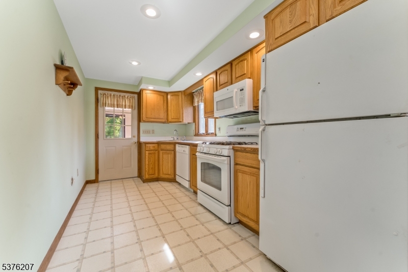 6 Franklin Street Washington, NJ 07882 - Photo 14 of 38 a kitchen with a refrigerator a stove top oven and cabinets