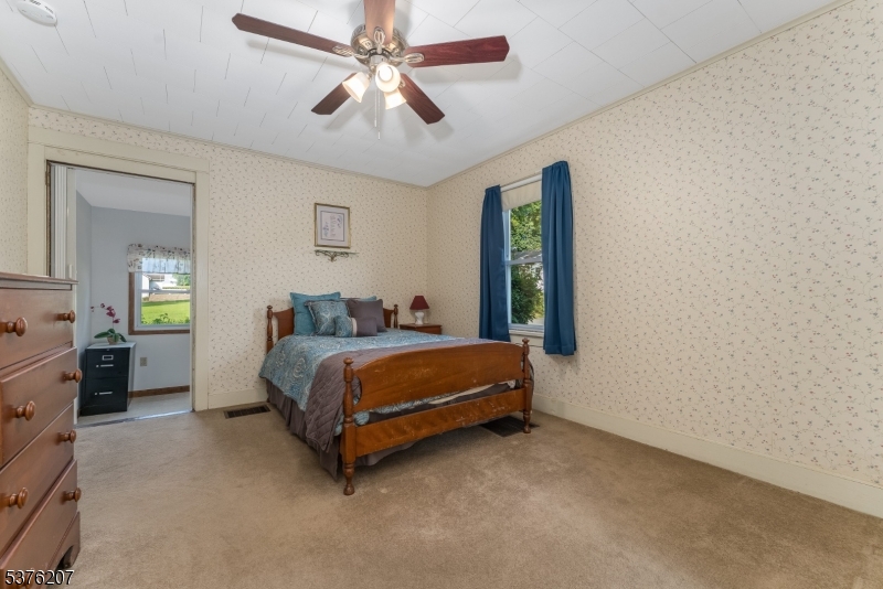 6 Franklin Street Washington, NJ 07882 - Photo 24 of 38 a spacious bedroom with a bed and a chandelier